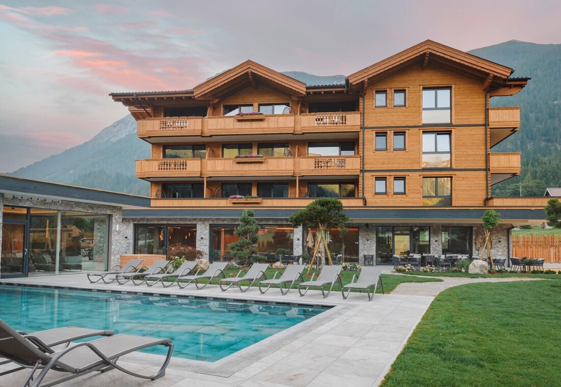 Frontansicht Hotel mit Pool zum Sonnenuntergang