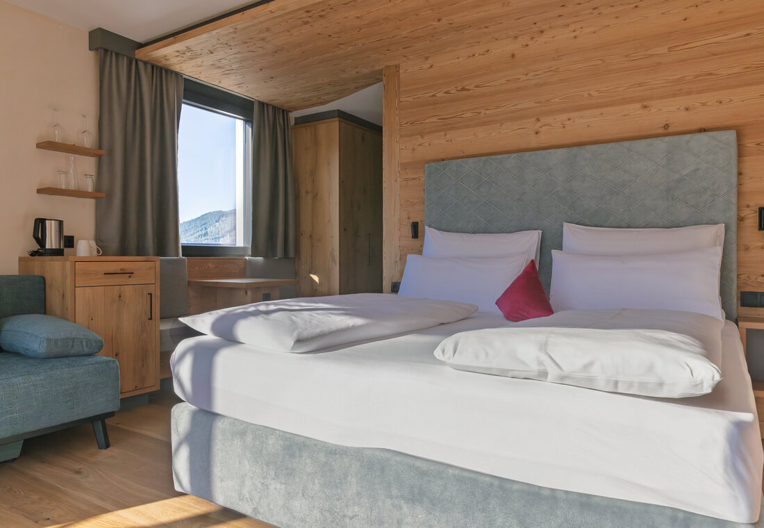 Bett in der Juniorsuite mit Sonnenlicht