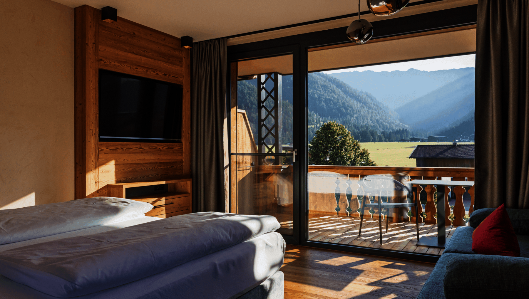 Bett mit Blick zum Balkon und Sonnenlicht
