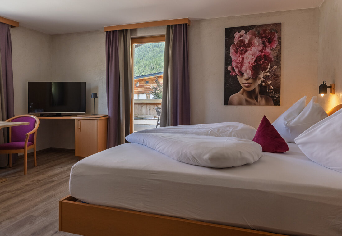 Schlafzimmer mit Kunstdruck und Sessel