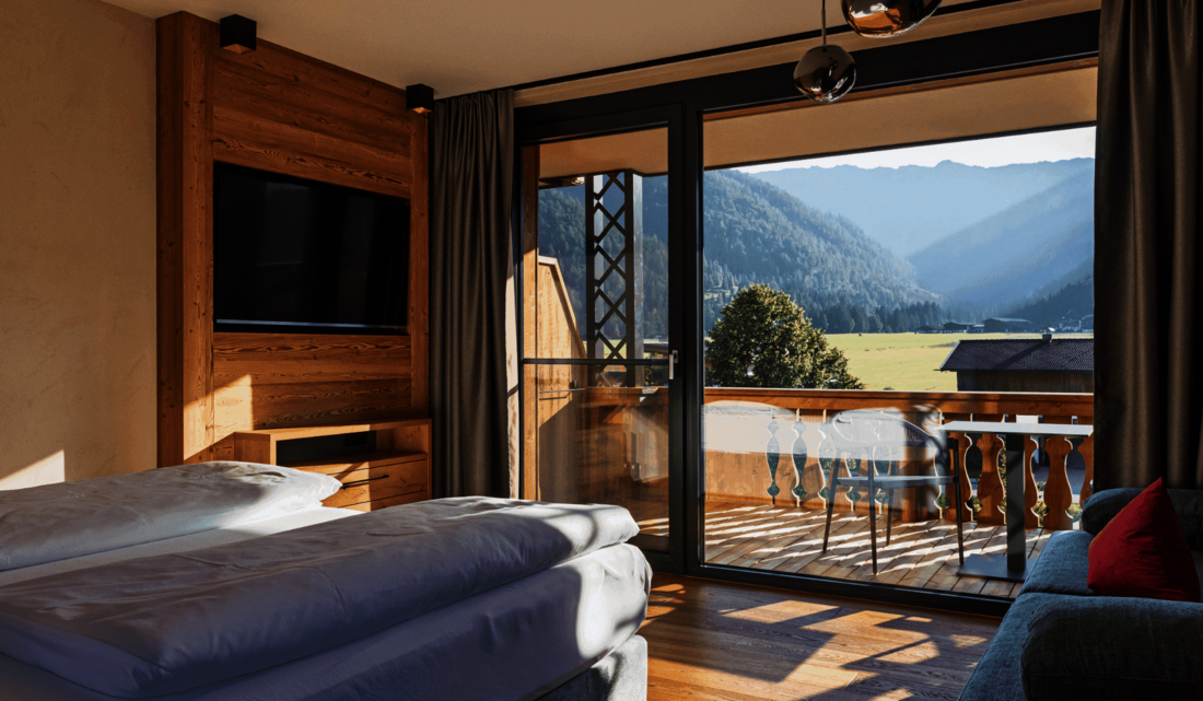 Bett in der Juniorsuite mit Blick nach draußen