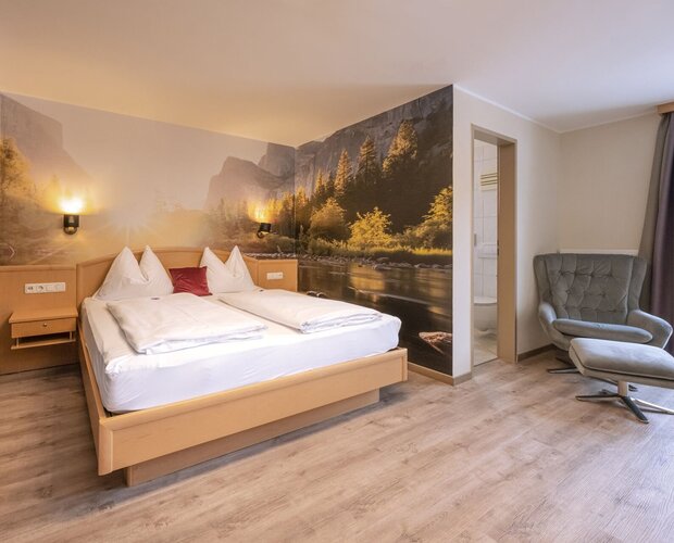 Zimmer mit Doppelbett und großem Wandbild