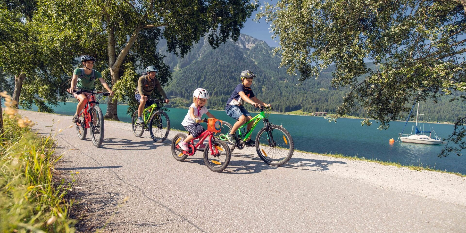 Familie beim Radfahren am Ufer des Achensees