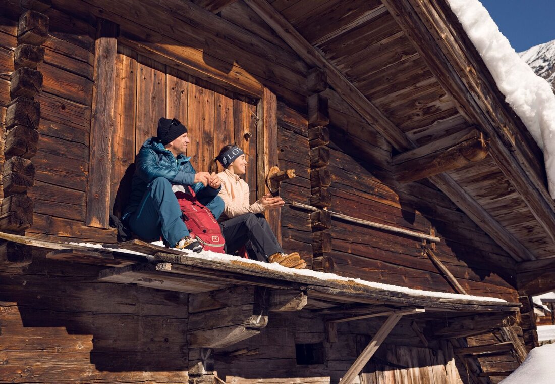 Mann und Frau machen Pause an einer Hütte