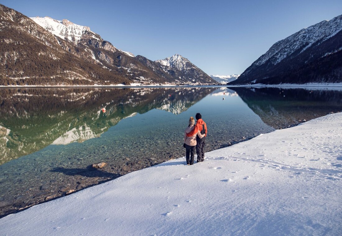 Mann und Frau stehen am Achensee im Winter