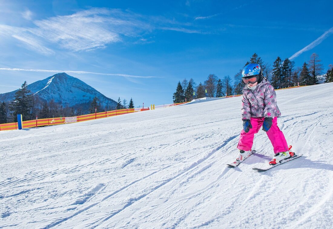 Kind beim Skifahren auf der Piste